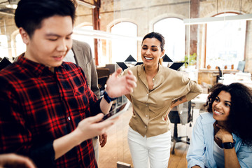 Multiracial young people chatting and laughing at work