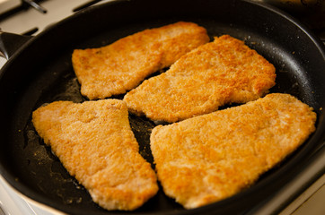 Breaded chicken cutlets in a pan