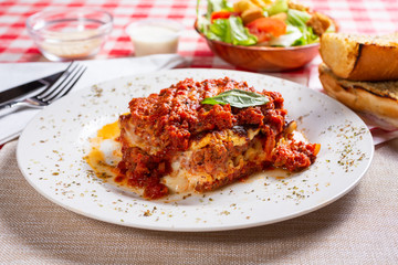 A view of a lasagna dinner, in a restaurant or kitchen setting.