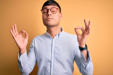 Young handsome hispanic business man wearing nerd glasses over yellow background relax and smiling...