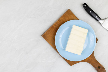 White cheese on the plate with copy space. Flat lay above cheese served on the plate with wooden...