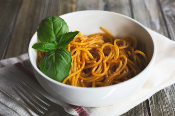 A view of a bowl of spaghetti, in a restaurant or kitchen setting.