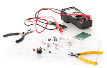 Different electronic parts or components, measurement tool and pliers on white with pcb wiring...