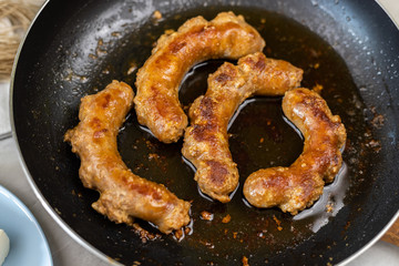 Fried Sausages in the frying pan with blurred background