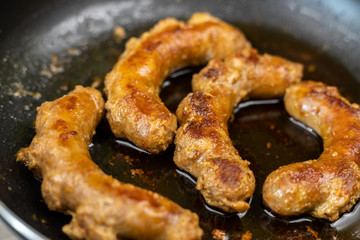 Fried Sausages in the frying pan with blurred background