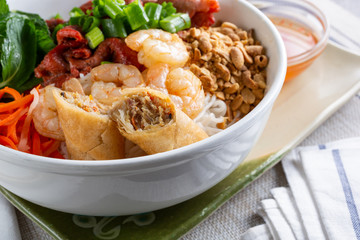 A closeup view of a bowl of Vietnamese vermicelli noodles known as Bún, in a restaurant or kitchen setting.