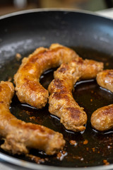 Fried Sausages in the frying pan with blurred background