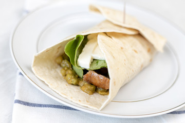 Tortilla served with fried sausage and green peas