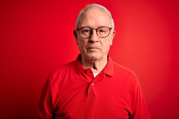 Grey haired senior man wearing glasses and casual t-shirt over red background depressed and worry for distress, crying angry and afraid. Sad expression.