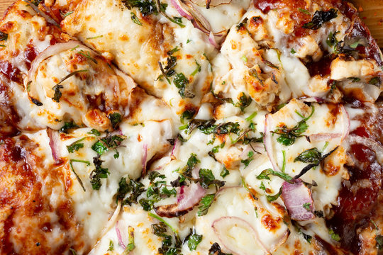 A top down closeup view of a small barbecue chicken and onion pizza pie, as a background image.