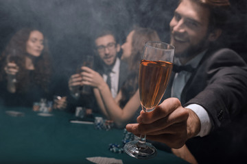 poker player raising a glass of wine