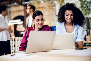 Beautiful young women using laptop at work