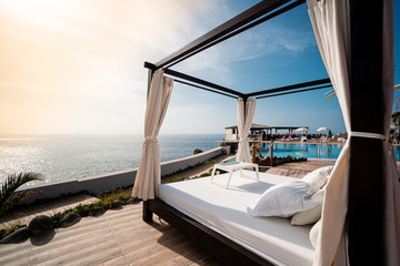 Sunbathing bed in a luxury pool hotel with stunning ocean views - 335946911