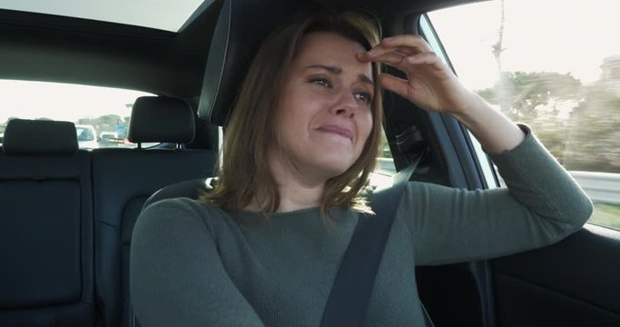 Sad woman crying while driving car after loss and death of parent for coronavirus