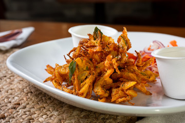 A view of an Indian dish called pakora, in a restaurant or kitchen setting.