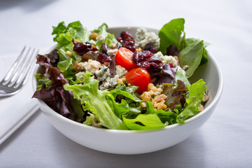 A view of a California garden salad, in a restaurant or kitchen setting.
