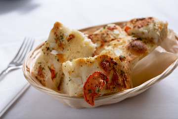 A view of a basket of focaccia bread in a restaurant or kitchen setting.
