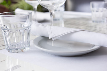 A view of a white motif fine dining place setting inside a restaurant. 