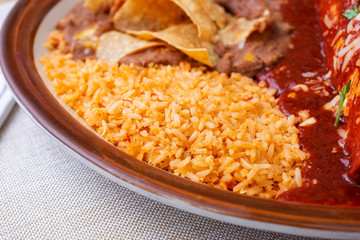 A view of a plate featuring a side of Mexican rice, in a restaurant or kitchen setting.