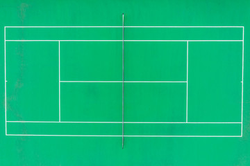 Aerial top down view of a tennis court  green pavement, baseline, singles' sideline, doubles' sideline, net, net posts, center mark, service line, doubles alley, at new American residential community