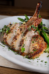 A view of a plate of a chopped seasoned pork chop, in a restaurant or kitchen setting.