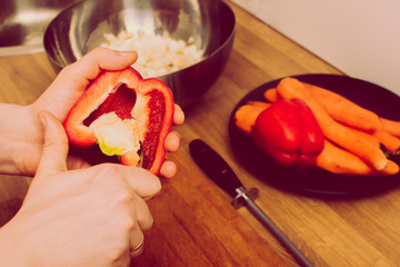 Man holding red, sweet pepper or paprika. Health and healthy lifesyle concept. Man cuts a red bell...