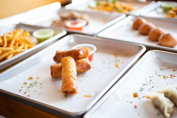 A view of several varieties of street food appetizers in a restaurant or kitchen setting.