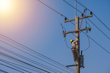 The power lineman uses insutated tool to open the connection of the transformer from the high...