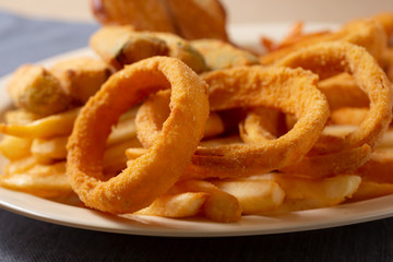 A view of a plate of deep fried appetizers, in a restaurant or kitchen setting.