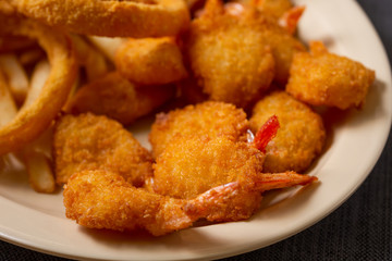 A view of plate of deep fried appetizers, featuring shrimp, in a restaurant or kitchen setting.