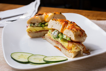 A view of a plate of a breakfast bagel sandwich, in a restaurant or kitchen setting.