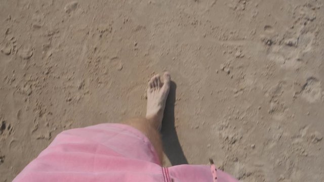 slow point of view motion video of the legs and foots of a young men walking on the sand and water of the beach of Solanas, Maldonado, Punta del Este