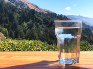 Glass of water by a beautiful mountainside landscape