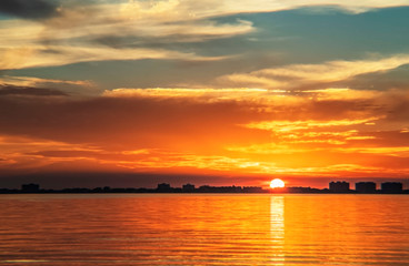 Fototapeta na wymiar Indian Beach 5, Sarasota, Florida, beautiful orange, red sunset, visible sun, ripples, clouds 