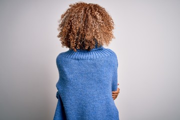 Young beautiful african american woman wearing turtleneck sweater over white background standing...