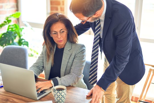 Two middle age business workers working together. Woman suffering sexual harassment at the office