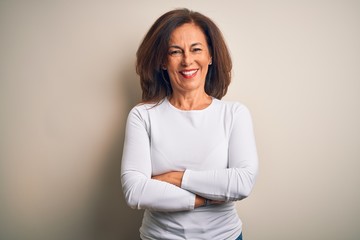 Fototapeta premium Middle age beautiful woman wearing casual t-shirt standing over isolated white background happy face smiling with crossed arms looking at the camera. Positive person.