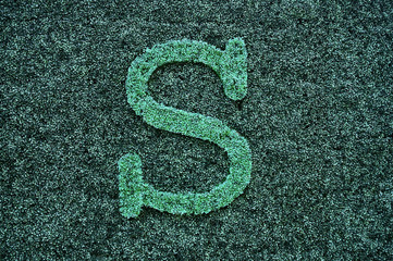 Letter symbols on green artificial lawn