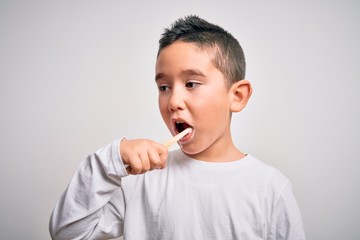 Young little kid boy brushing her teeth using tooth brush and oral paste, cleaning teeth and tongue as healthy health care morning routine. Learning dental education