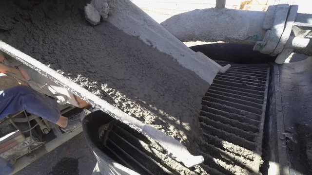 Concrete Truck Chute Pouring Wet Cement Mix into Crane Pump