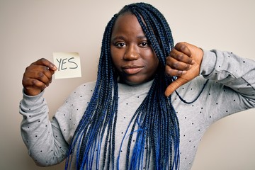 Young african american plus size woman with braids holding reminder paper with yes message with...