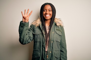 Young african american woman wearing winter parka coat over isolated background showing and pointing up with fingers number four while smiling confident and happy.