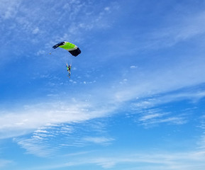 Skydiver maneuvering under the blue sky