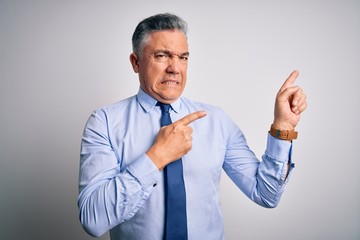 Middle age handsome grey-haired business man wearing elegant shirt and tie Pointing aside worried and nervous with both hands, concerned and surprised expression