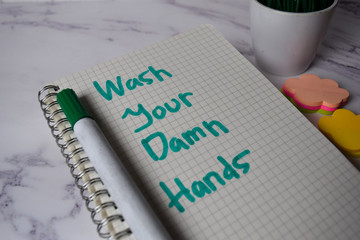 Wash Your Damn Hands write on a book and keyword isolated on Office Desk. Healthcare/Medical Concept