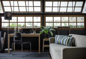 Modern home office creative space perfect for working from home lifestyle with laptop on the desk and sofa in the living room, Quarantine isolation during the Coronavirus (COVID-19) health crisis