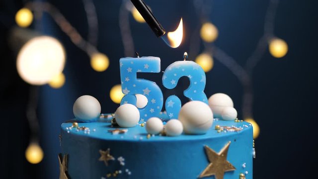 Birthday cake number 53 stars sky and moon concept, blue candle is fire by lighter and then blows out. Copy space on right side of screen if required. Close-up and slow motion