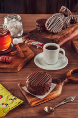 Honey cookie chocolate covered on the wooden table with coffee and various honey breads - pão de mel