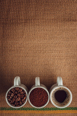 Brazialian coffee in liquid, powder and beans state on a jute background - Top view