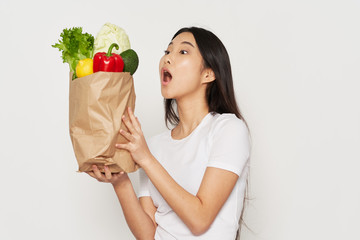young woman holding a bag full of groceries